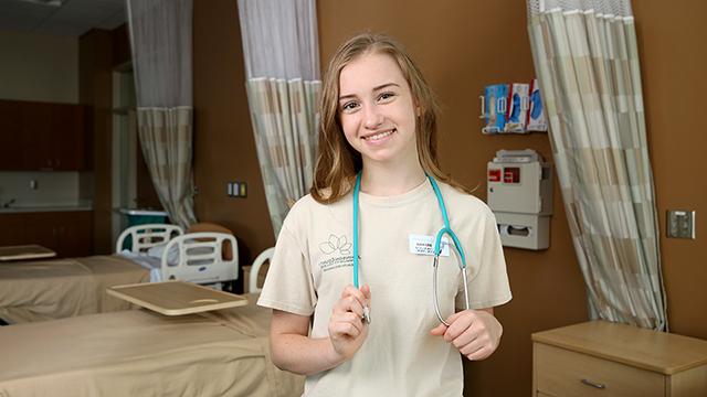 早期的大学 student wearing C N A scrubs with a stethoscope around her neck